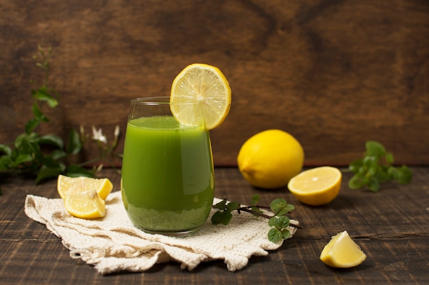 Foto gratuita arreglo con batido verde y limones.