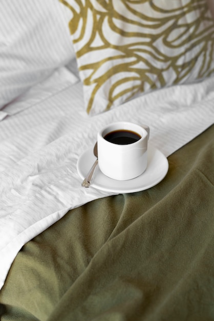 Foto gratuita arreglo de cama acogedora de alto ángulo con taza de café