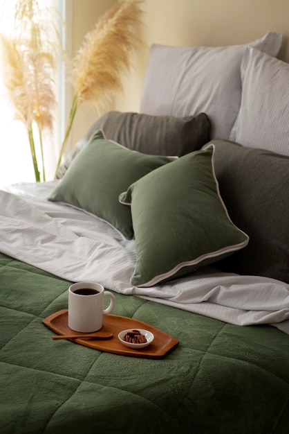 Foto gratuita arreglo de cama acogedora de alto ángulo con taza de café