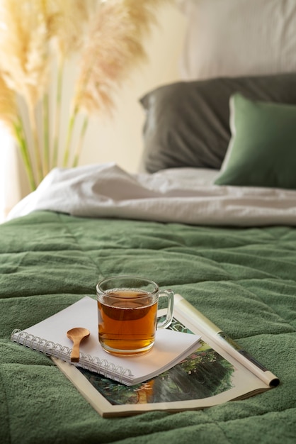 Arreglo de cama de ángulo alto con revista y taza.