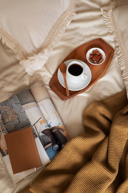 Arreglo de cama de ángulo alto con revista y taza.