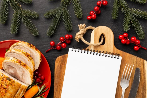 Arreglo de comida navideña con bloc de notas vacío