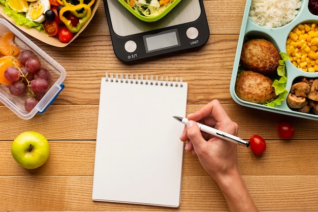 Arreglo de comida sabrosa vista superior con cuaderno vacío