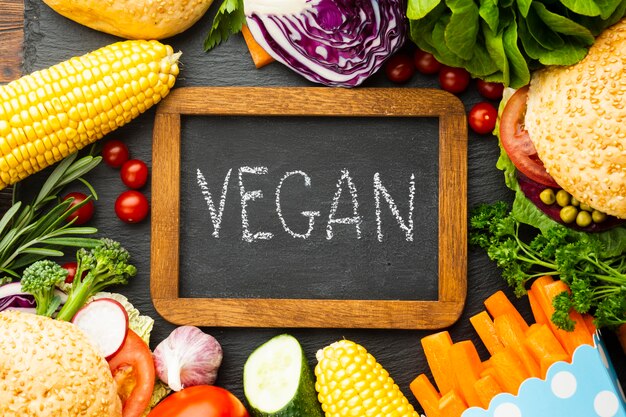 Arreglo de comida saludable con letras veganas en pizarra