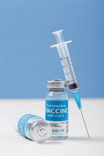 Arreglo de coronavirus con botella de vacuna y jeringa.