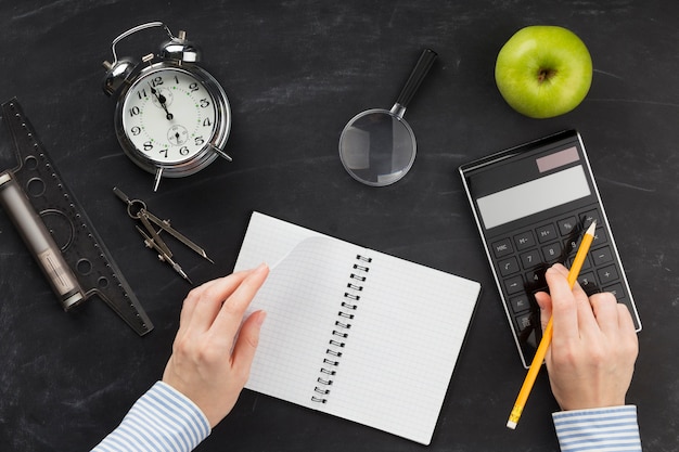 Arreglo de elementos educativos con cuaderno vacío