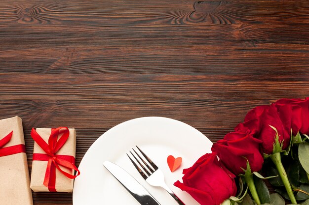 Arreglo encantador para la cena del día de San Valentín sobre fondo de madera con espacio de copia