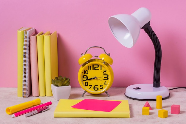 Foto gratuita arreglo de escritorio con lámpara y reloj