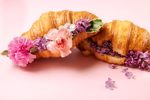 Foto gratuita arreglo floral y croissants de alto ángulo.