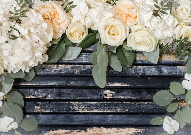Arreglo floral de hermosas rosas blancas sobre fondo de madera, concepto de flores