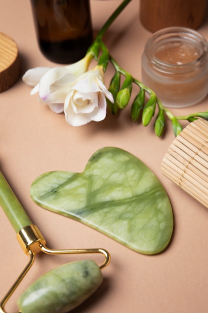 Foto gratuita arreglo de gua sha y productos para el cuidado alto ángulo