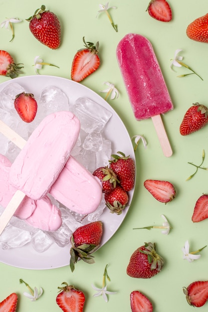 Arreglo de helado en palitos con fresas