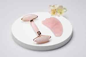 Foto gratuita arreglo de herramientas de gua sha rosa de alto ángulo