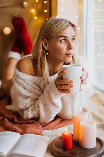 Arreglo de higge de invierno con velas junto a la mujer