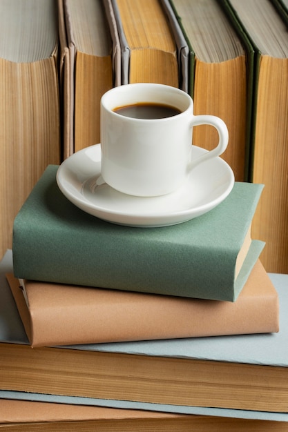 Arreglo de libros con taza de café