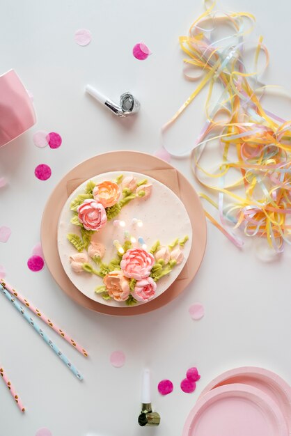 Arreglo de mesa para evento de cumpleaños con pastel y confeti.