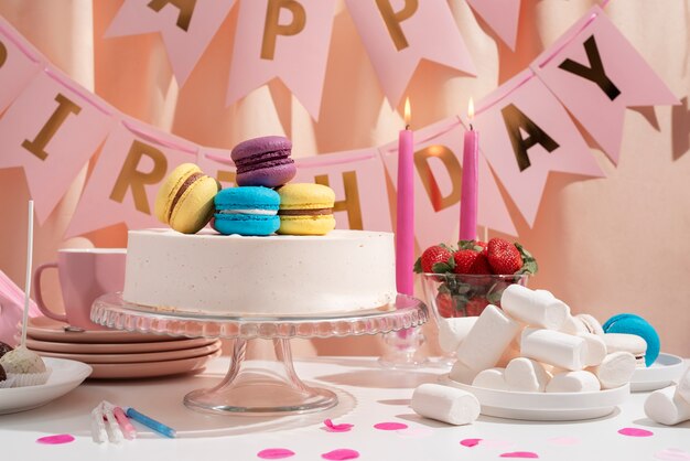Arreglo de mesa para evento de cumpleaños con pastel y macarons.