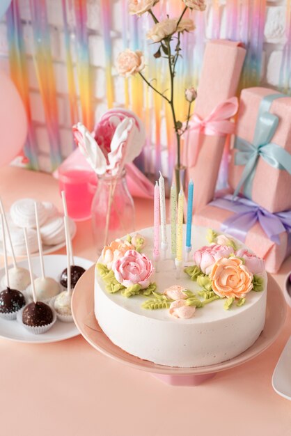 Arreglo de mesa para evento de cumpleaños con pastel y regalos.
