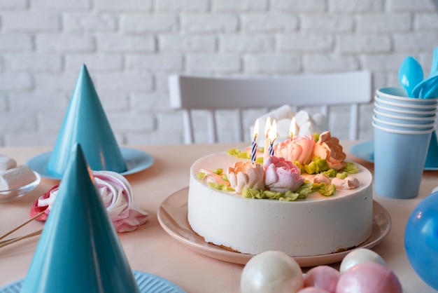 Arreglo de mesa para evento de cumpleaños con pastel y sombreros de cumpleaños.