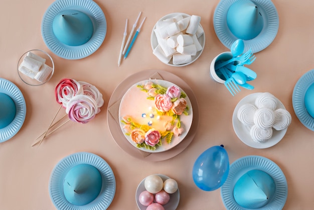 Arreglo de mesa para evento de cumpleaños con pastel y sombreros de cumpleaños.