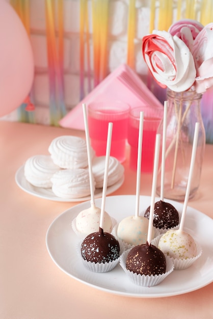 Arreglo de mesa para evento de cumpleaños con piruletas y jugo.