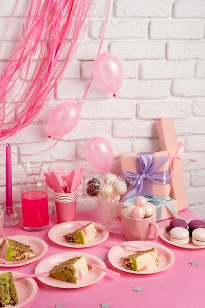 Foto gratuita arreglo de mesa para evento de cumpleaños con rebanadas de pastel y macarrones