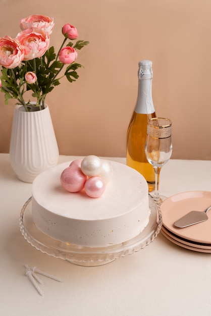 Arreglo de mesa para evento de cumpleaños con torta y botella de champagne