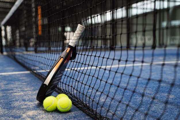 Arreglo de paleta y pelotas de tenis de alto ángulo.