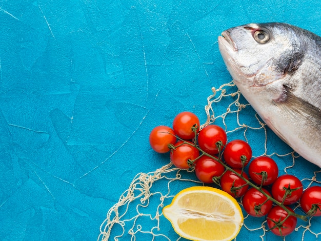 Arreglo de pescado con tomates planos laicos