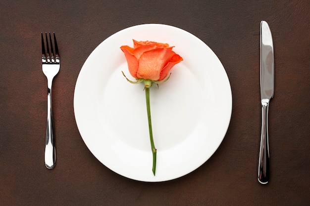 Arreglo plano para la cena de San Valentín con rosa naranja