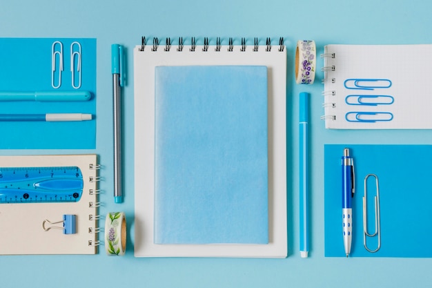 Arreglo plano de cuadernos y bolígrafos