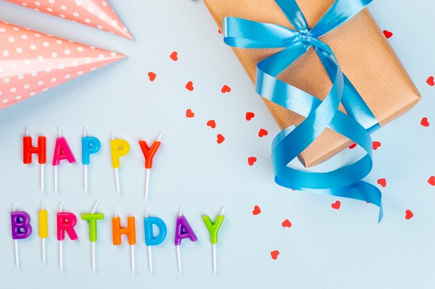 Arreglo plano de cumpleaños con regalo y gorro de fiesta