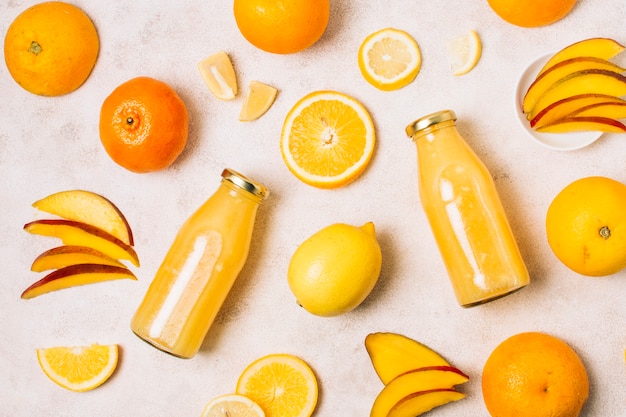 Foto gratuita arreglo plano con frutas naranjas y batidos.