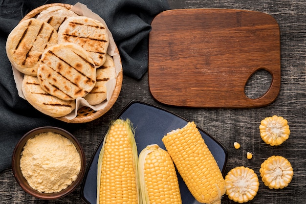 Foto gratuita arreglo plano de maíz y arepas