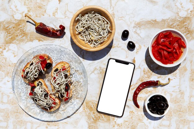 Arreglo de plato tradicional de gulas con smartphone