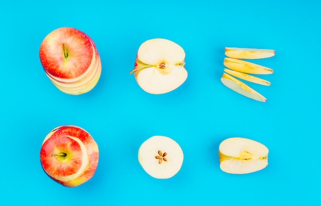 Arreglo de rodajas de manzana sobre fondo azul