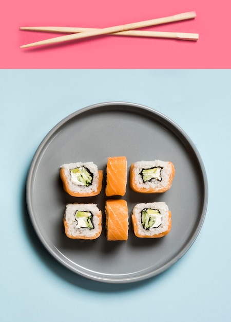 Foto gratuita arreglo de rollos de sushi con palillos y salsa de soja