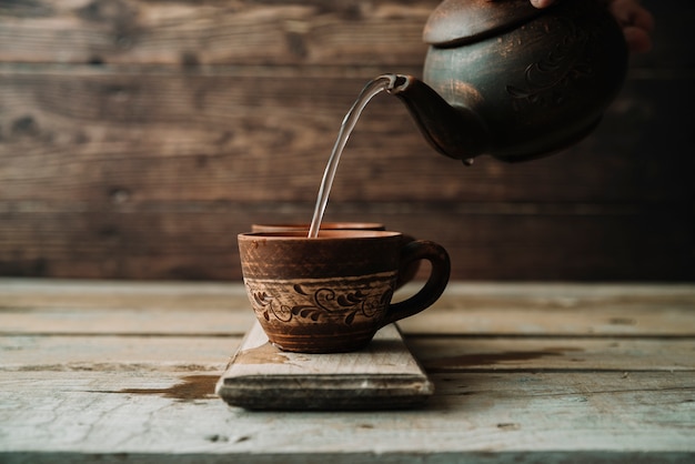 Arreglo rústico de tetera y taza.