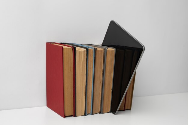 Arreglo de tabletas y libros en la mesa.
