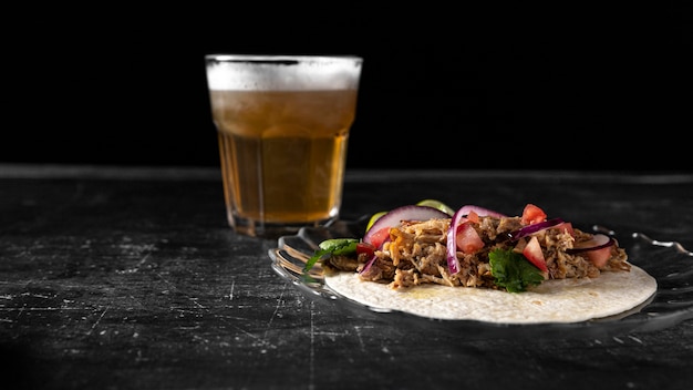 Arreglo con taco y vaso de cerveza.