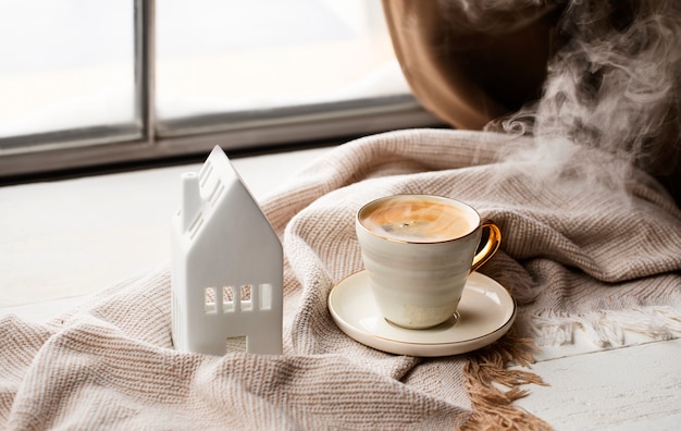 Arreglo de taza de café y casa blanca ángulo alto
