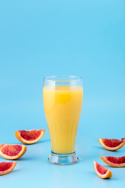 Foto gratuita arreglo con vaso de jugo de naranja