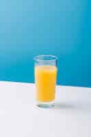 Foto gratuita arreglo con vaso de jugo de naranja