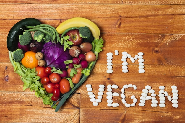 Foto gratuita arreglo vegetal en forma de corazón sobre fondo de madera