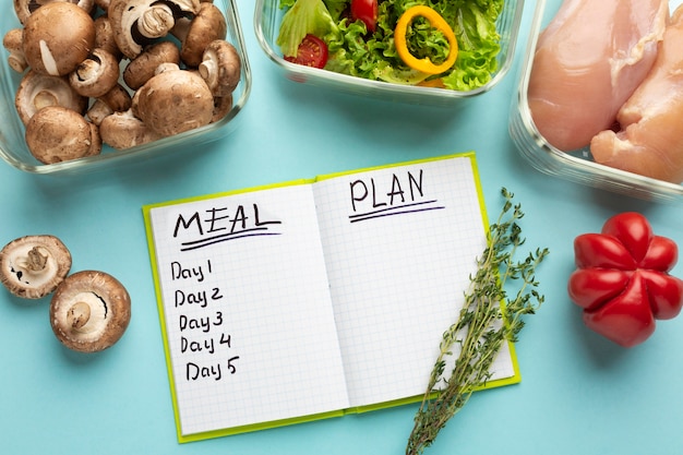 Foto gratuita arreglo de vista superior con cuaderno de planificación de comidas