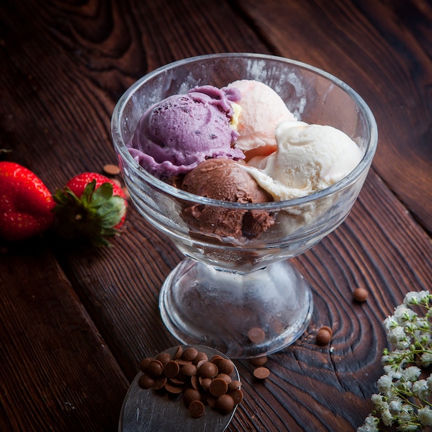 De arriba bolas de helado con gotas de chocolate y fresa y gypsophila en copa de helado