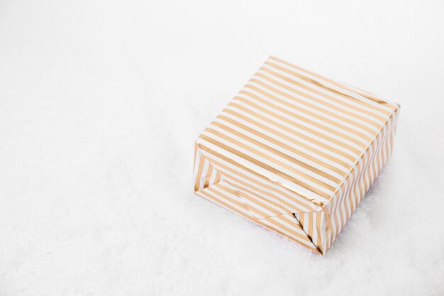 Desde arriba disparo de cajas de regalo brillantes decorados con cinta tendida en la nieve blanca