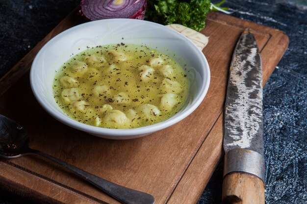 Desde arriba dushpara con cuchillo y cuchara y cebolla en la tabla de alimentos