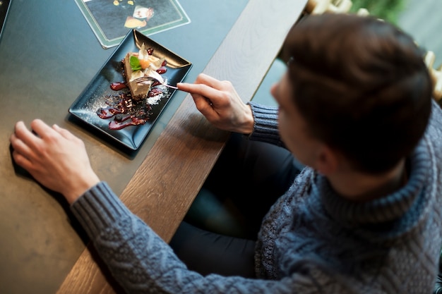 Foto gratuita desde arriba, el hombre disfruta de un postre en el café