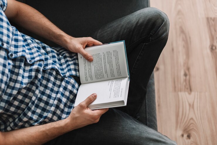 Foto gratuito desde arriba, hombre leyendo en el sofá